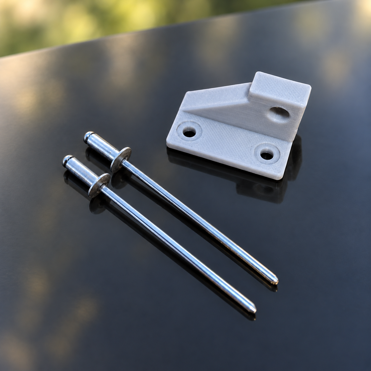 Light-grey window latch catch with rivets shown.